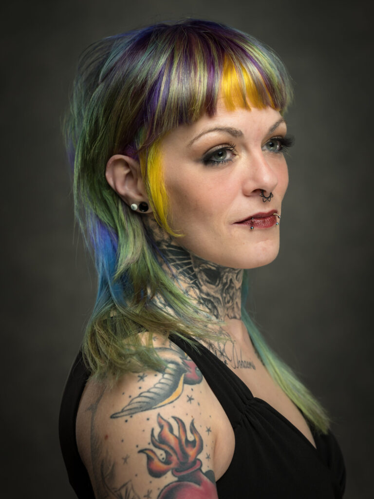 Kleurenfoto van vrouw met kleurrijk haar en tatoeages gemaakt voor een kapperswedstrijd en is gemaakt door portretfotograaf Ed van der Weijden.