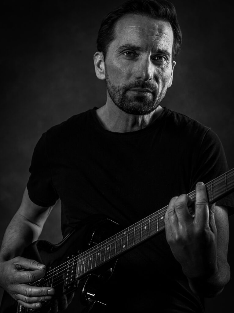 Stoere zwartwit foto in opdracht met gitaar. Gemaakt door portretfotograaf Ed van der Weijden.