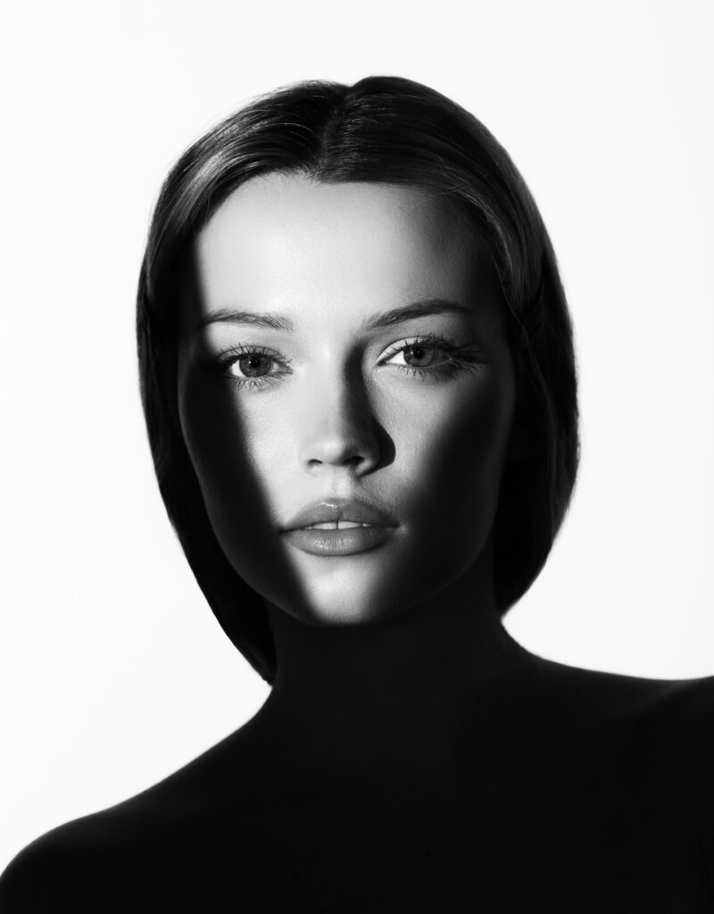Creatieve studioshoot van een jonge vrouw met veel schaduw in het gezicht.