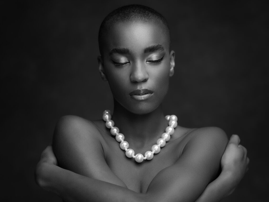 art foto van een donkere vrouw met parelketting